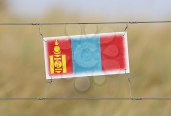 Border fence - Old plastic sign with a flag - Mongolia