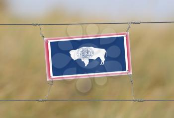 Border fence - Old plastic sign with a flag - Wyoming
