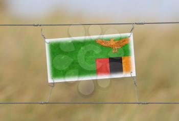 Border fence - Old plastic sign with a flag - Zambia