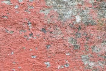 Closeup of chipped paint on old red wall