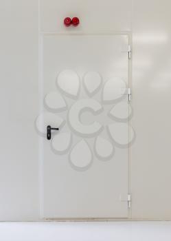 Shot of a white metal door in a white wall