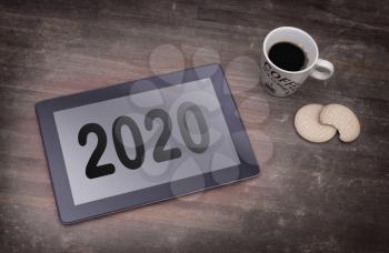 Tablet touch computer gadget on wooden table, vintage look - 2020