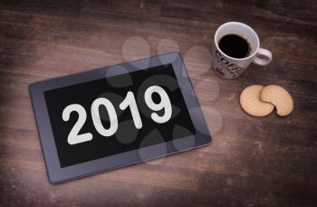 Tablet touch computer gadget on wooden table, vintage look - 2019