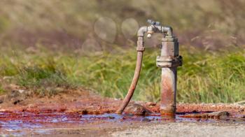 Spring in Iceland, tapping water, red of iron