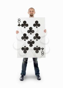 Businessman with large playing card - Eight of clubs