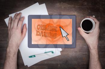 Online dating on a tablet - concept of love, orange