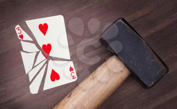 Hammer with a broken card, vintage look, three of hearts