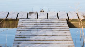 Long wooden jetty at lake at cold winter day