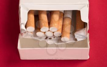 Cigarettes in a pack, isolated on red