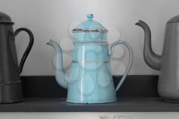 Antique blue kettle in a row of three kettles