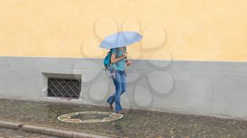 Mysterious girl walking with umbrella on rainy day