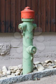 Green fire hydrant on a city sidewalk, Austria