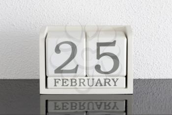White block calendar present date 25 and month February on white wall background