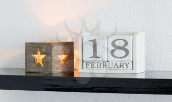 White block calendar present date 18 and month February on white wall background