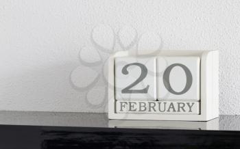 White block calendar present date 20 and month February on white wall background