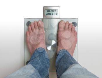 Closeup of man's feet on weight scale - Balance your life