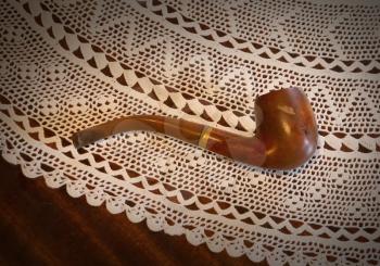 Old pipe on a wooden table, vintage setting