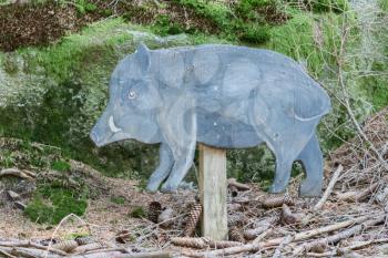 Education in the forest - wooden wild boar waiting to be spotted by children - Selective focus