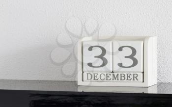 White block calendar present date 33 and month December on white wall background - Extra day