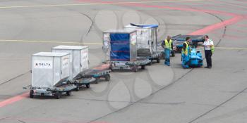 AMSTERDAM - JUNE 29, 2017: Planes are being loaded at Schiphol Airport June 29, 2017 in Amsterdam, The Netherlands. The airport handles over 45 million passengers per year with almost 100 airlines flying from here.