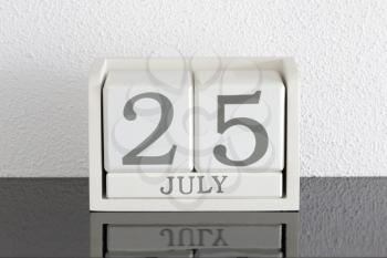 White block calendar present date 25 and month July on white wall background