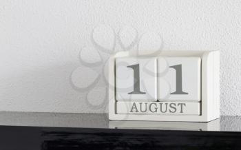 White block calendar present date 11 and month August on white wall background