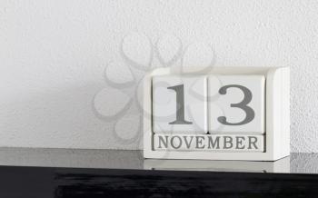 White block calendar present date 13 and month November on white wall background