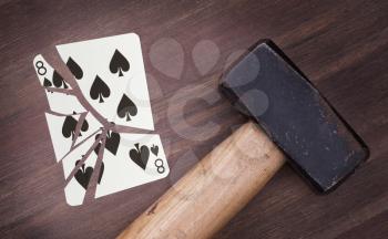 Hammer with a broken card, vintage look, eight of spades