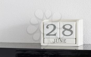 White block calendar present date 28 and month June on white wall background