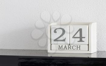 White block calendar present date 24 and month March on white wall background