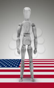 Wood figure mannequin standing on flag - USA