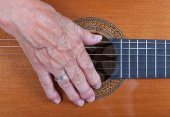 Close up on an old woman's hand playing guitar