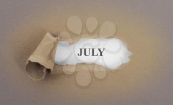 Text appearing behind torn brown envelop - July