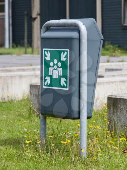 Evacuation assembly point sign on a green bin