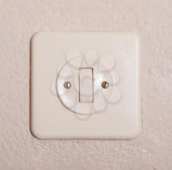 Press turn on/off electrical switch, old plaster wall