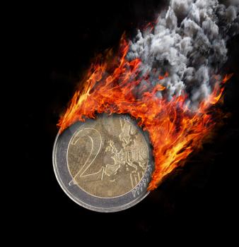Burning coin with a trail of fire and smoke - 2 euro