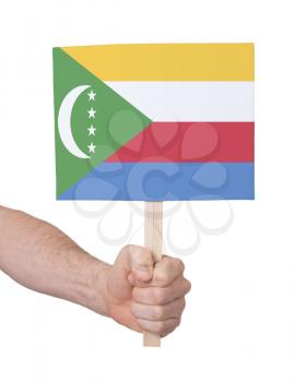 Hand holding small card, isolated on white - Flag of Comoros