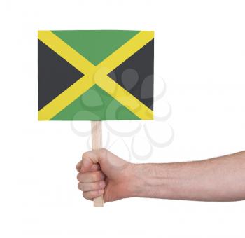 Hand holding small card, isolated on white - Flag of Jamaica