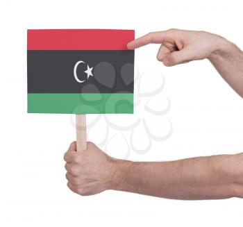 Hand holding small card, isolated on white - Flag of Libya