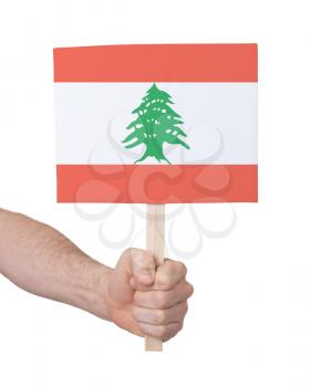 Hand holding small card, isolated on white - Flag of Lebanon