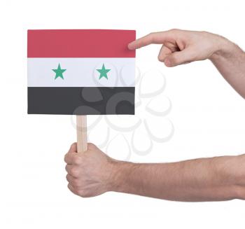 Hand holding small card, isolated on white - Flag of Syria