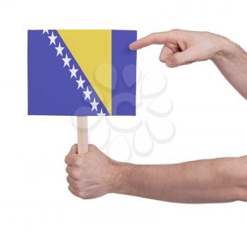 Hand holding small card, isolated on white - Flag of Bosnia Herzegovina