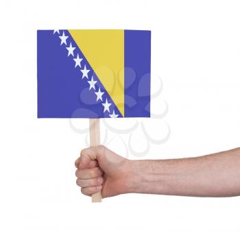 Hand holding small card, isolated on white - Flag of Bosnia Herzegovina