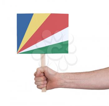 Hand holding small card, isolated on white - Flag of Seychelles