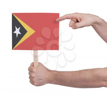 Hand holding small card, isolated on white - Flag of East Timor