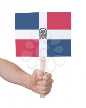 Hand holding small card, isolated on white - Flag of Dominican Republic