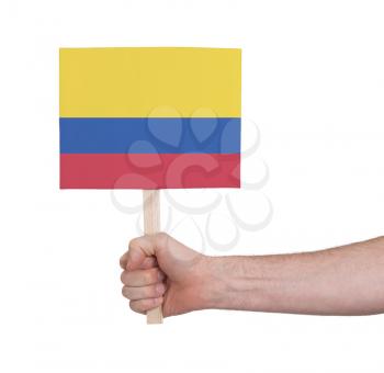 Hand holding small card, isolated on white - Flag of Colombia