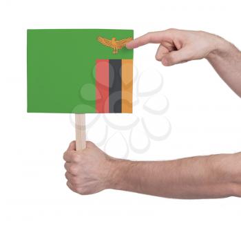 Hand holding small card, isolated on white - Flag of Zambia