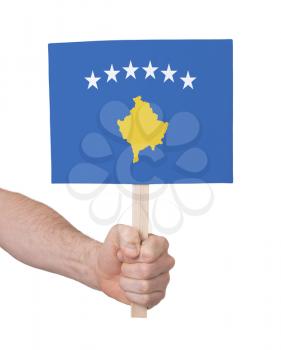 Hand holding small card, isolated on white - Flag of Kosovo