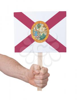 Hand holding small card, isolated on white - Flag of Florida